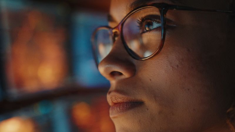 A systems supervisor monitoring automated workflow data metrics on digital screens.